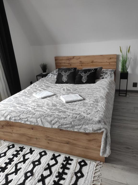 - une chambre avec un grand lit et une tête de lit en bois dans l'établissement Willa Ewelinka, à Zakopane