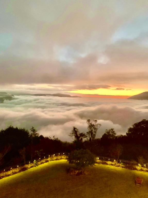 a view of a foggy field with the sun rising above the clouds at Junyi Landscape Villa in Ren&#39;ai