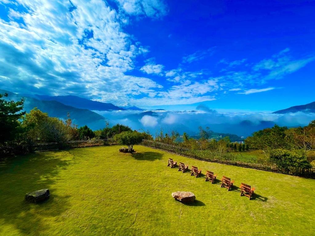 a group of benches sitting in a grass field at Junyi Landscape Villa in Ren&#39;ai