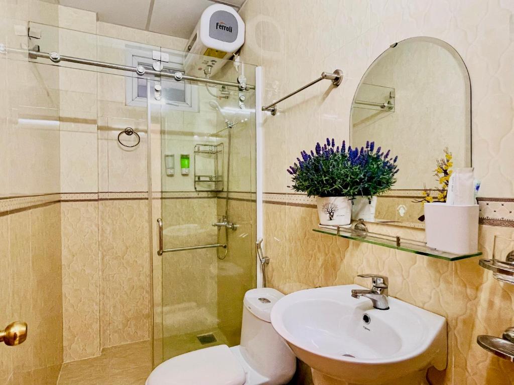 e bagno con doccia, servizi igienici e lavandino. di Dalat Colico Hotel a Da Lat