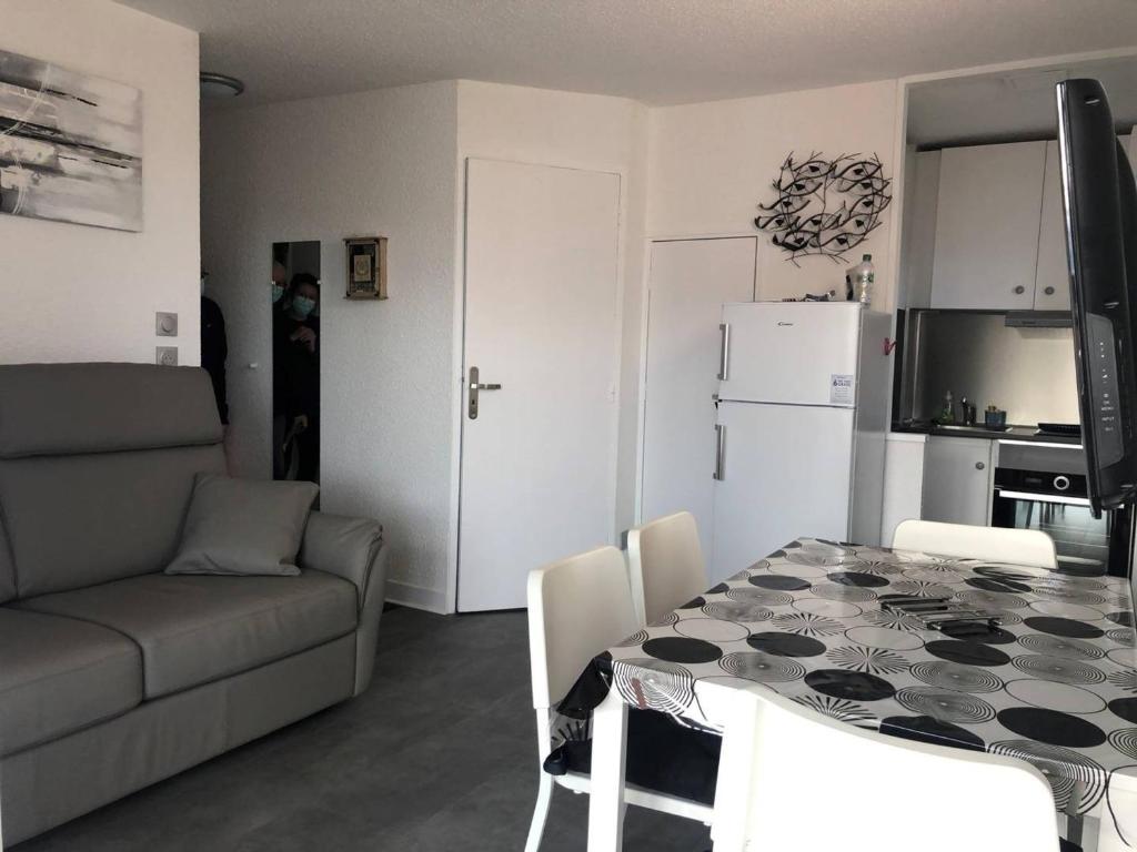 kuchnia oraz salon ze stołem i kanapą w obiekcie Appartement moderne, climatisé, quartier calme, proche commodités, avec parking privatif - FR-1-723-17 w Cap d'Agde