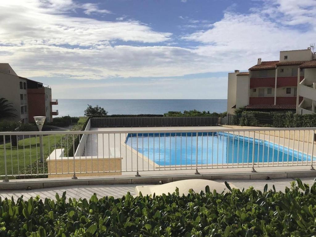 une piscine sur le côté d'un immeuble dans l'établissement Appartement Rez-de-Jardin 5 Pers, 2min Plage, Terrasse, Vue Mer, Garage - FR-1-723-26, au Cap d'Agde