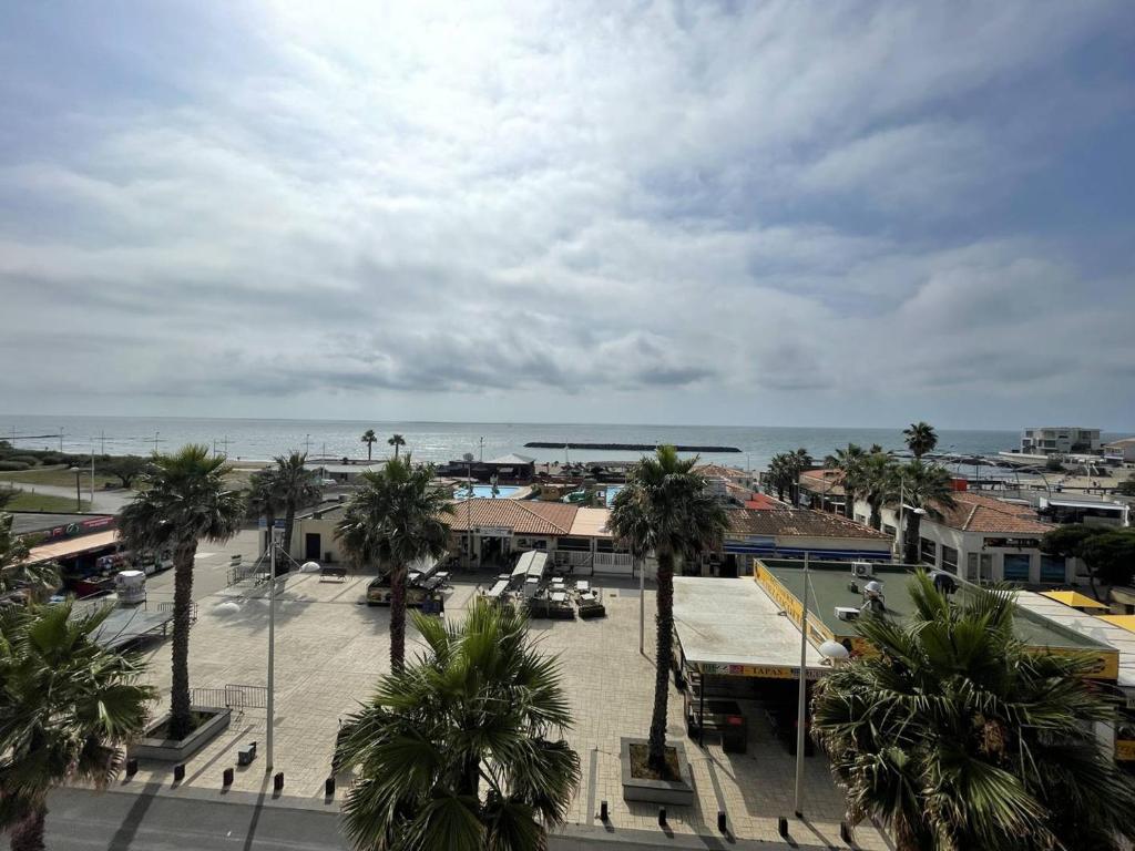 une vue d'une ville avec des palmiers et l'océan dans l'établissement Studio confortable au Cap d'Agde, proche plage, 4 pers - FR-1-723-46, au Cap d'Agde