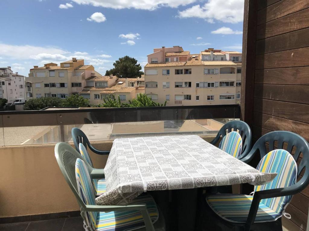 een tafel en stoelen op een balkon met uitzicht op de stad bij Studio Cap d'Agde, 2 pièces, 4 personnes - FR-1-723-28 in Cap d'Agde