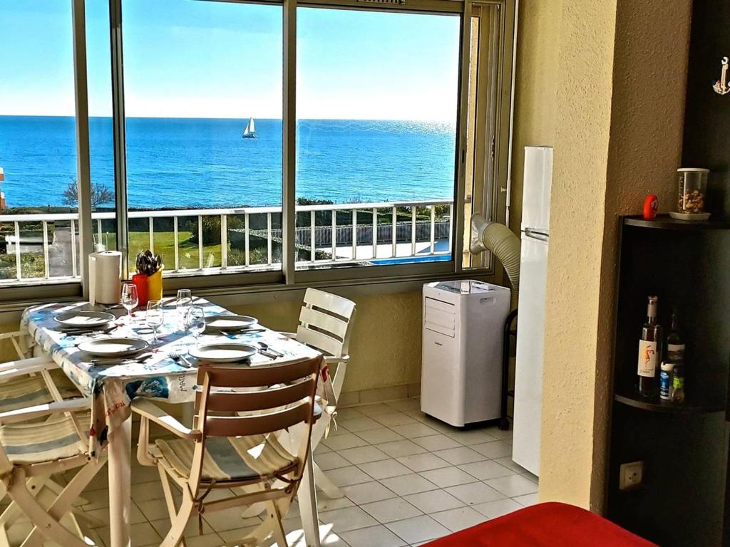 une cuisine avec une table et une vue sur l'océan dans l'établissement Studio cabine avec piscine, parking, climatisation, proche plage - FR-1-723-30, au Cap d'Agde