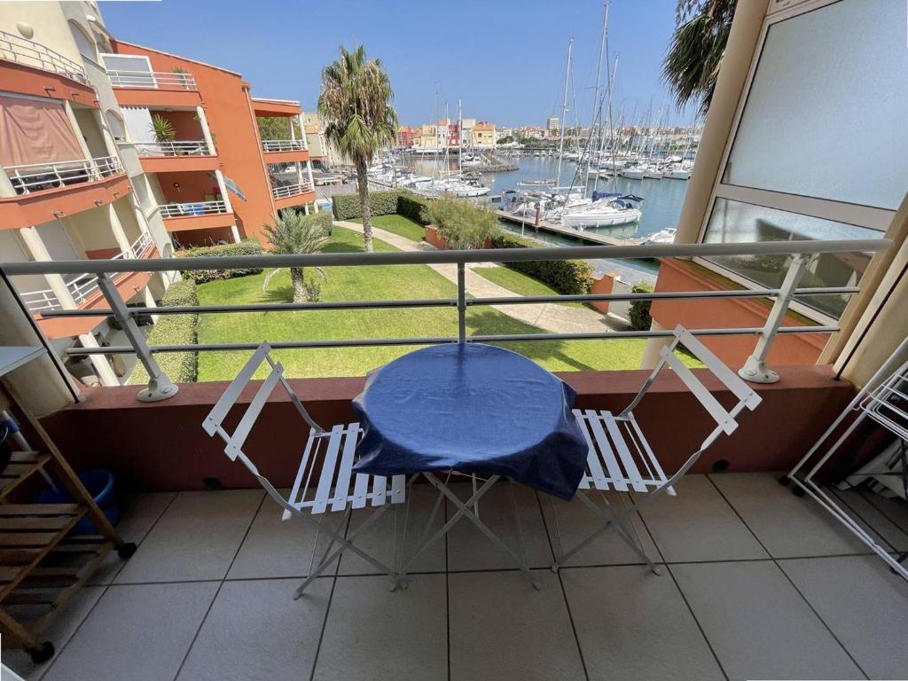 d'une table et de chaises sur un balcon avec vue sur le port. dans l'établissement Studio moderne, centre port avec piscine, parking, climatisation - Cap d'Agde - FR-1-723-37, au Cap d'Agde