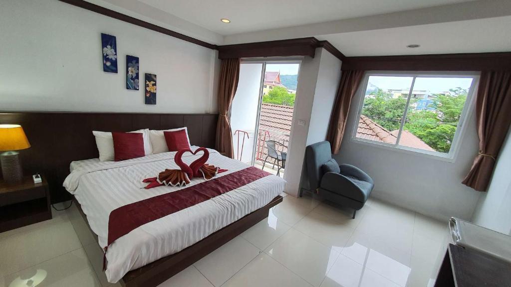 a bedroom with a large bed with a large window at Fruit Paradise in Patong Beach