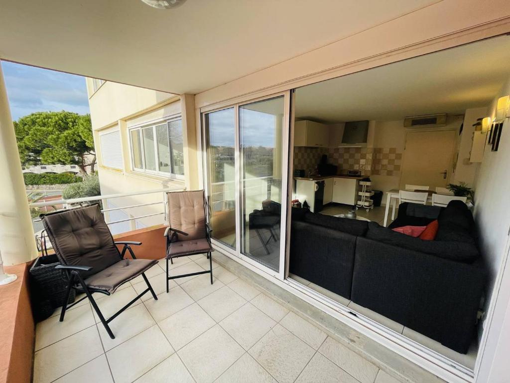 d'un balcon avec vue sur le salon. dans l'établissement Bel appartement climatisé avec piscine et balcon, proche plage et commerces - Cap d'Agde - FR-1-723-67, au Cap d'Agde