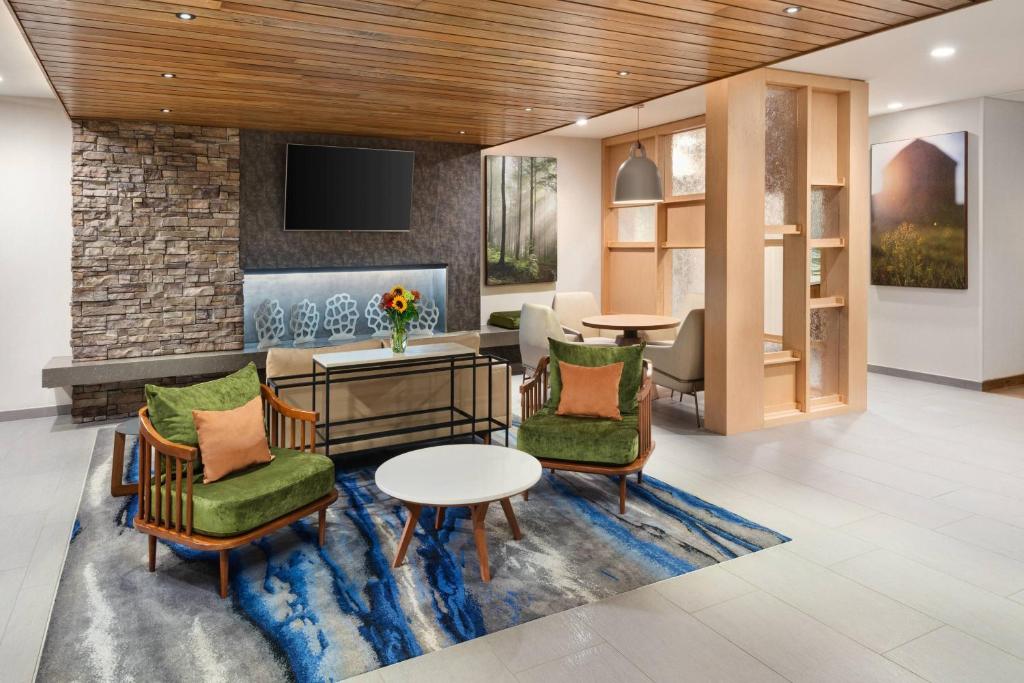 a lobby with chairs and a table and a tv at Fairfield Inn & Suites Santee in Santee