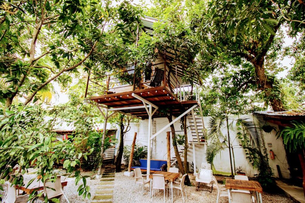 La Casona de Sara في هوندا: منزل شجرة به درج وطاولات وكراسي