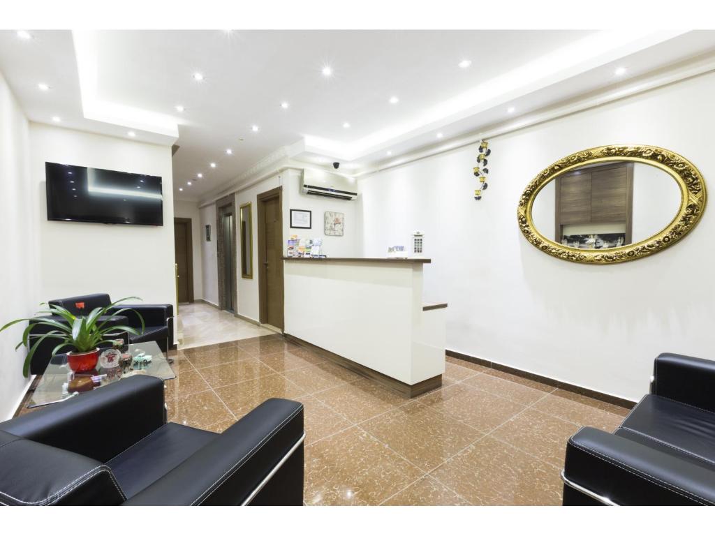 ein Wohnzimmer mit schwarzen Stühlen und einem Spiegel in der Unterkunft Zendy Suite Hotel in Istanbul