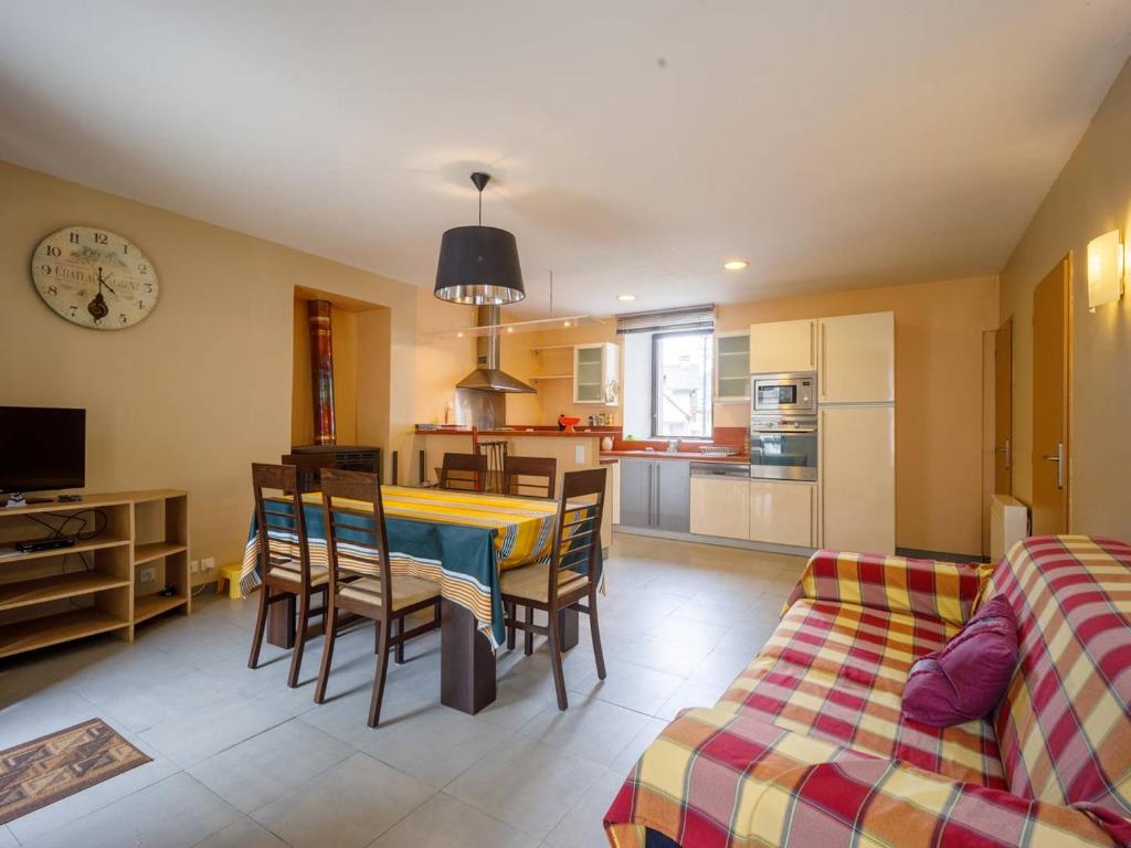 a kitchen and living room with a table and a couch at Maison Loudenvielle, 3 pièces, 6 personnes - FR-1-695-28 in Loudenvielle