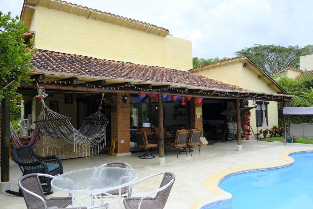 un patio con mesa y sillas junto a una piscina en Fincas Panaca Herreria 1 - San Judas en Quimbaya