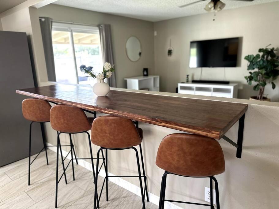 a kitchen with a wooden table with four bar stools at Cozy Bohemian Home w/ Hot Tub in Mesa in Mesa