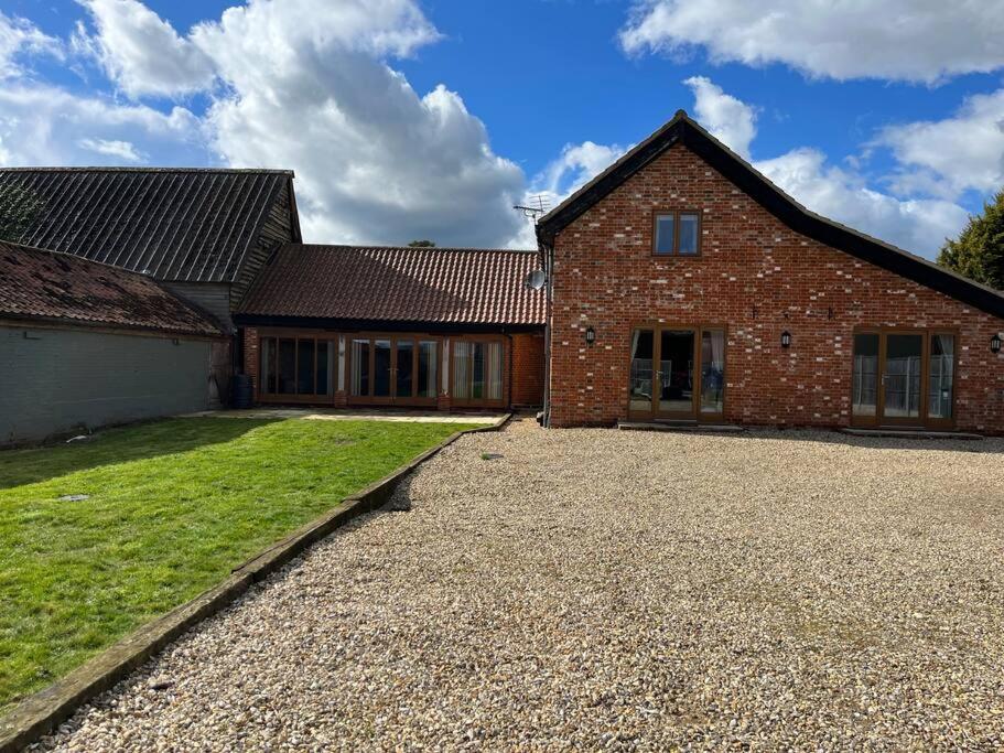 a large brick house with a large driveway at Charming Norfolk Barn Conversion in Barnham Broom in Norwich