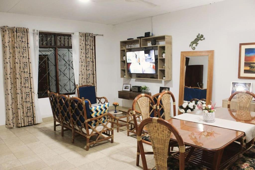 ein Wohnzimmer mit einem Tisch, Stühlen und einem TV in der Unterkunft Casa Montero, acogedora y amplia. Iquitos-Peru in Iquitos