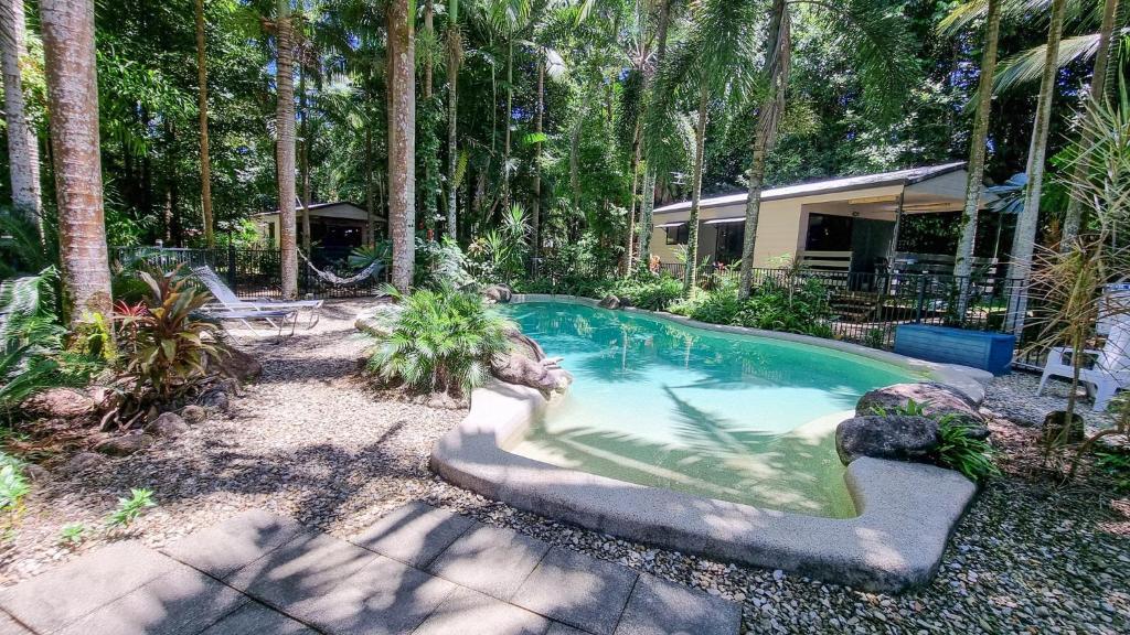 een zwembad in een tuin met palmbomen bij Boutique Bungalows in Mission Beach