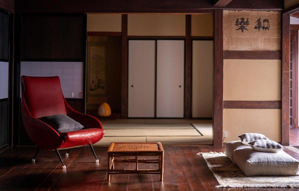 a living room with a red chair and a table at Hanakaijichi - Vacation STAY 74775v in Wajima