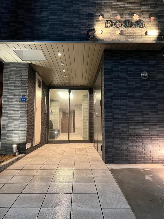 un accès à un bâtiment avec une porte en verre dans l'établissement DC桜の苑501洋室双人床, à Osaka