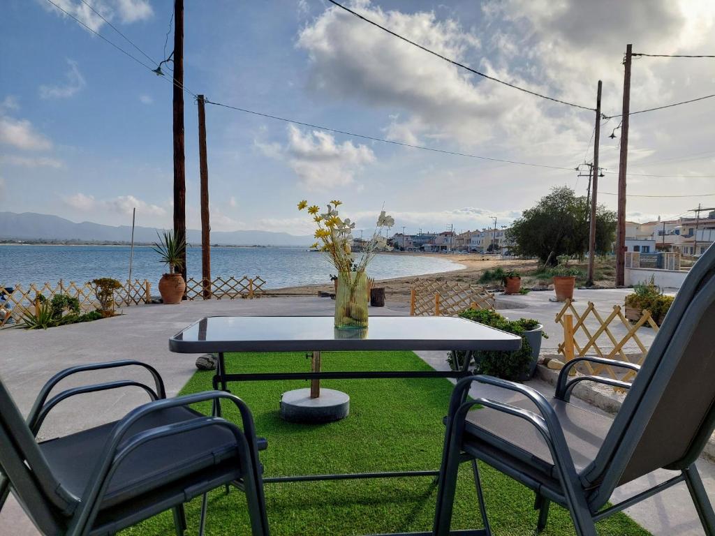 エラフォニソスにあるBahia- apartment by the sea,close to cedar forest!のテーブル、椅子2脚、花瓶付テーブル
