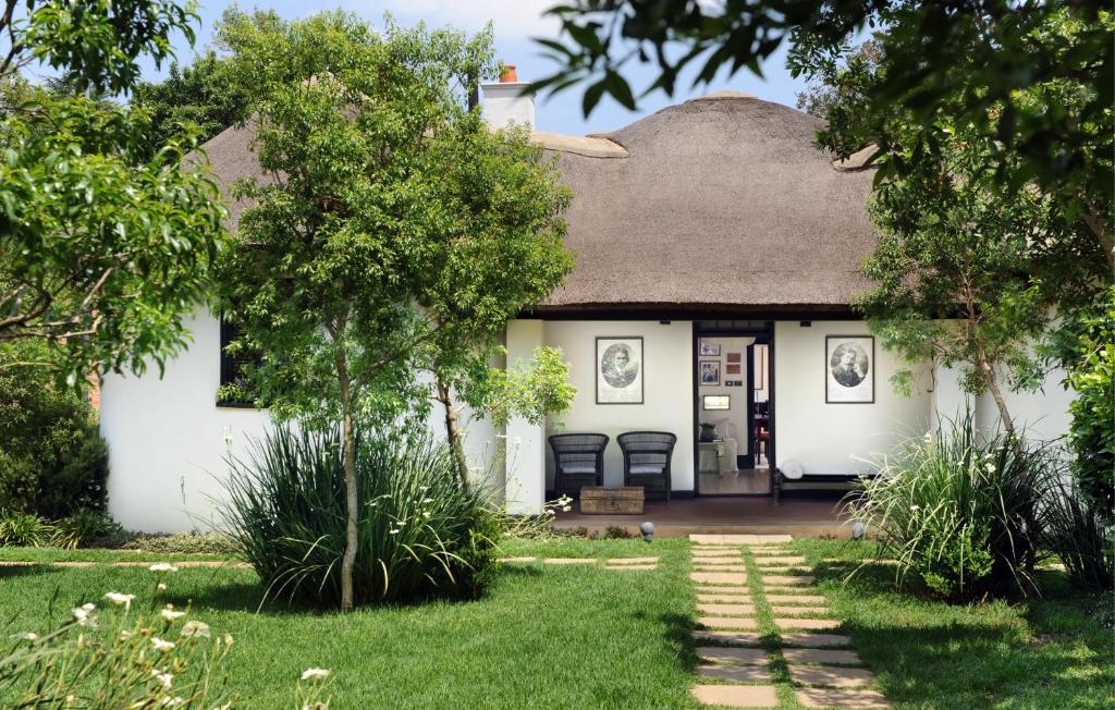 Casa blanca con techo de paja en Satyagraha House, en Johannesburgo