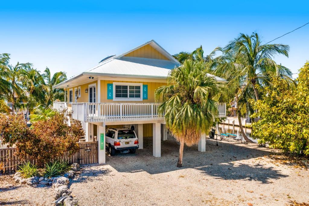 a yellow house with a car parked in front of it at Key Lime Time in Cudjoe Key