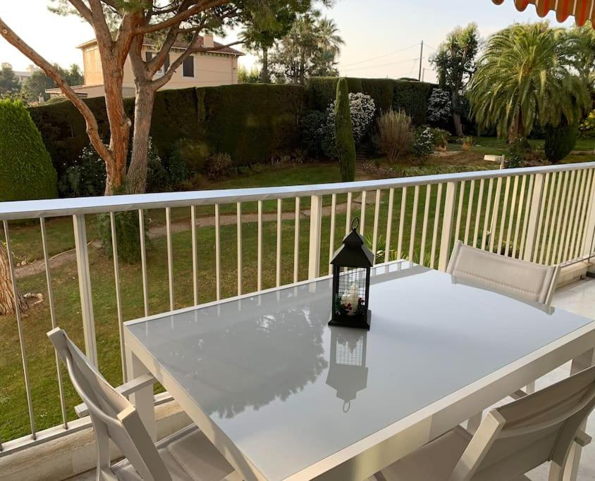 d'une table blanche et de deux chaises sur un balcon. dans l'établissement La Pinède - Appartment 3 bedrooms, à Vallauris