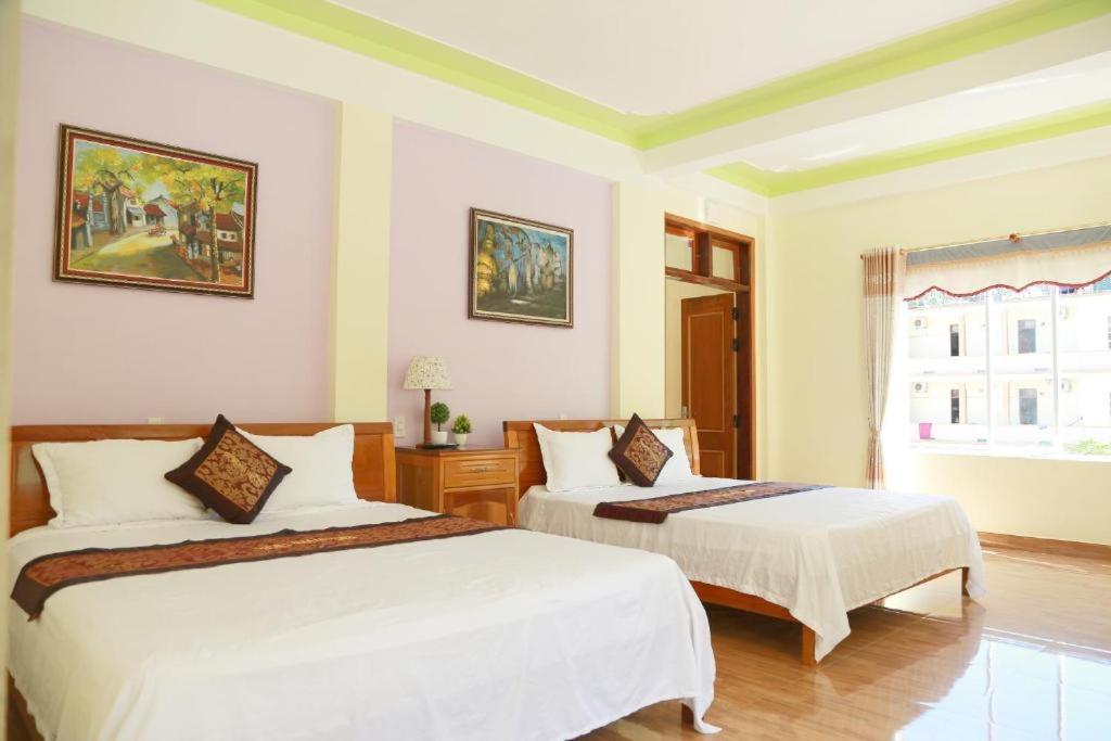 a bedroom with two beds and a window at Phong Nha Midtown hotel in Phong Nha