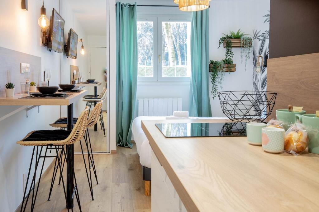 une cuisine avec un comptoir, des chaises et une table dans l'établissement Acapulco romantique, à Annecy