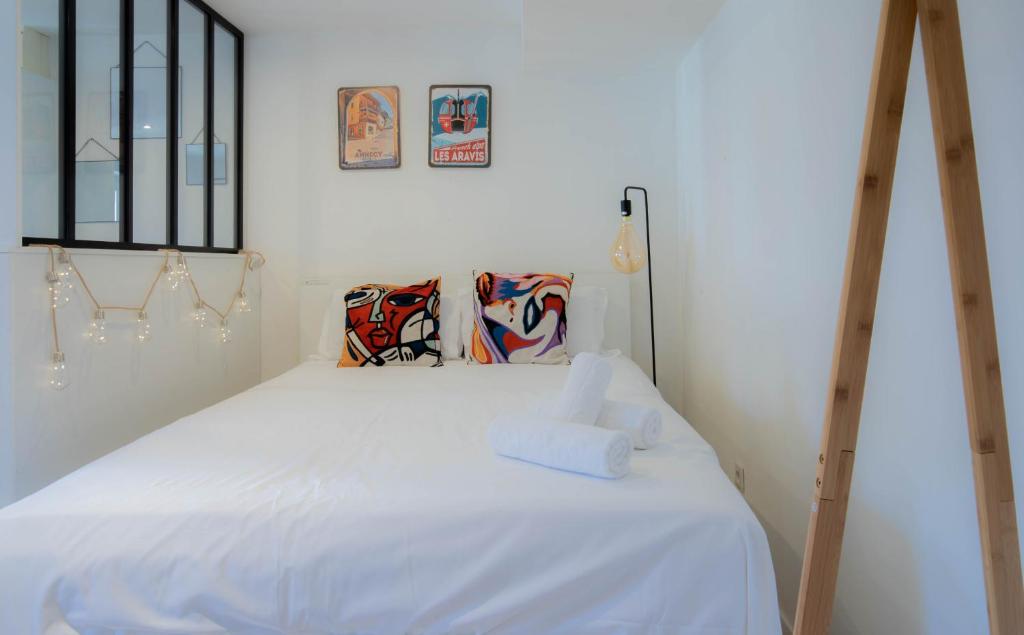 uma cama branca com duas almofadas em cima em Mystery emplacement 1er em Annecy