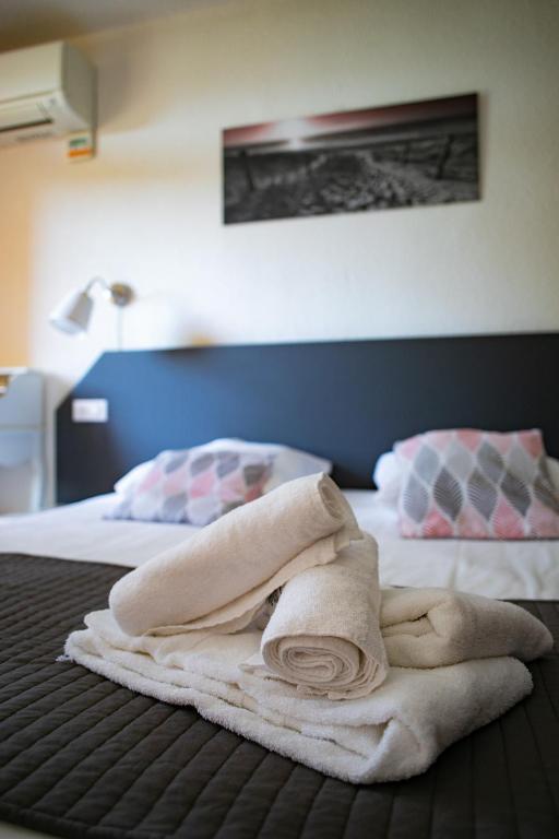a towel laying on top of a bed at Le Clos des Bruyères in Vallon-Pont-dʼArc