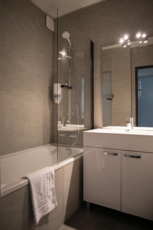 a bathroom with a tub and a sink and a bath tub at Le Clos des Bruyères in Vallon-Pont-dʼArc