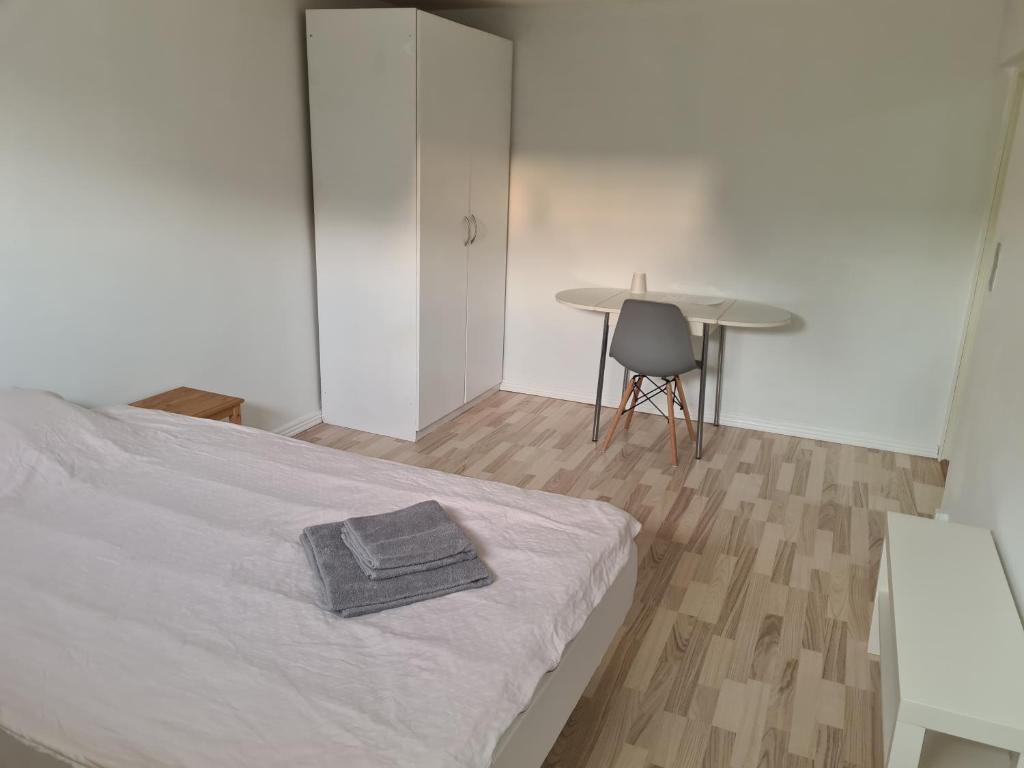 a bedroom with a bed and a table and a chair at Kristensen b@b in Hjallerup