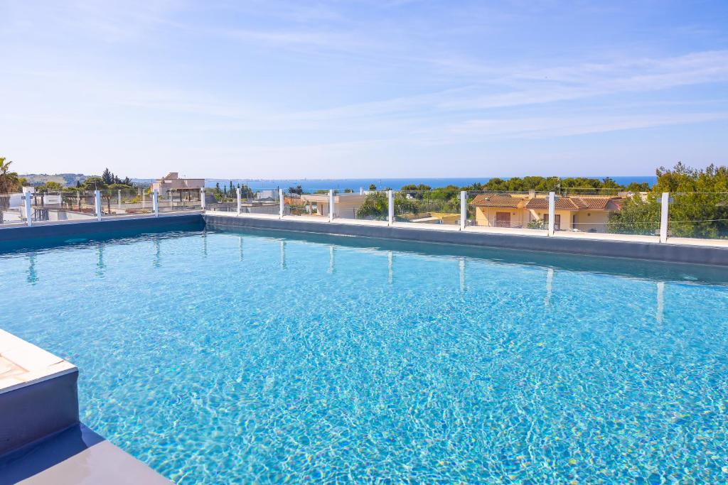 a large swimming pool with blue water at Aparthotel Residences Ludovica & Valentina - Piscina Panoramica Vista Mare in Santa Maria al Bagno