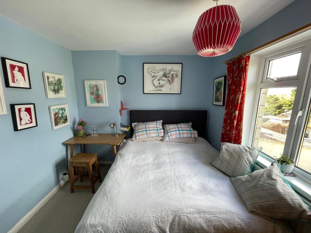a bedroom with a bed and a table and a window at Artist's home with views over Bath in Bath