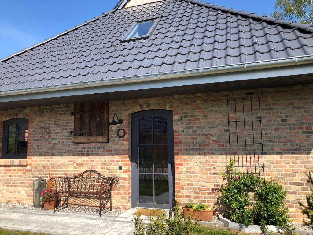 a brick house with a bench in front of it at Landhaus 1884 OFC 17 in Beiershagen