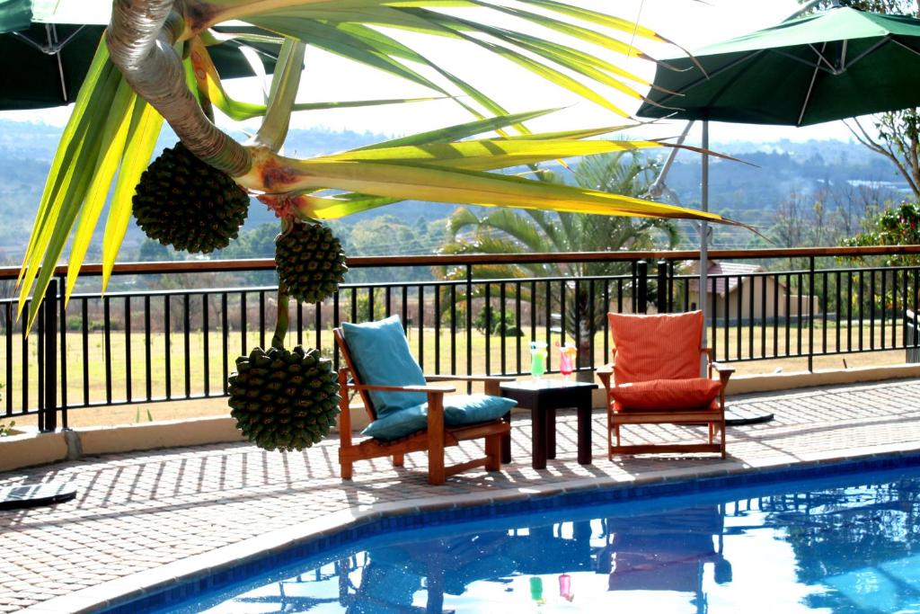 a swimming pool with two chairs and an umbrella at Destiny Lodge in White River