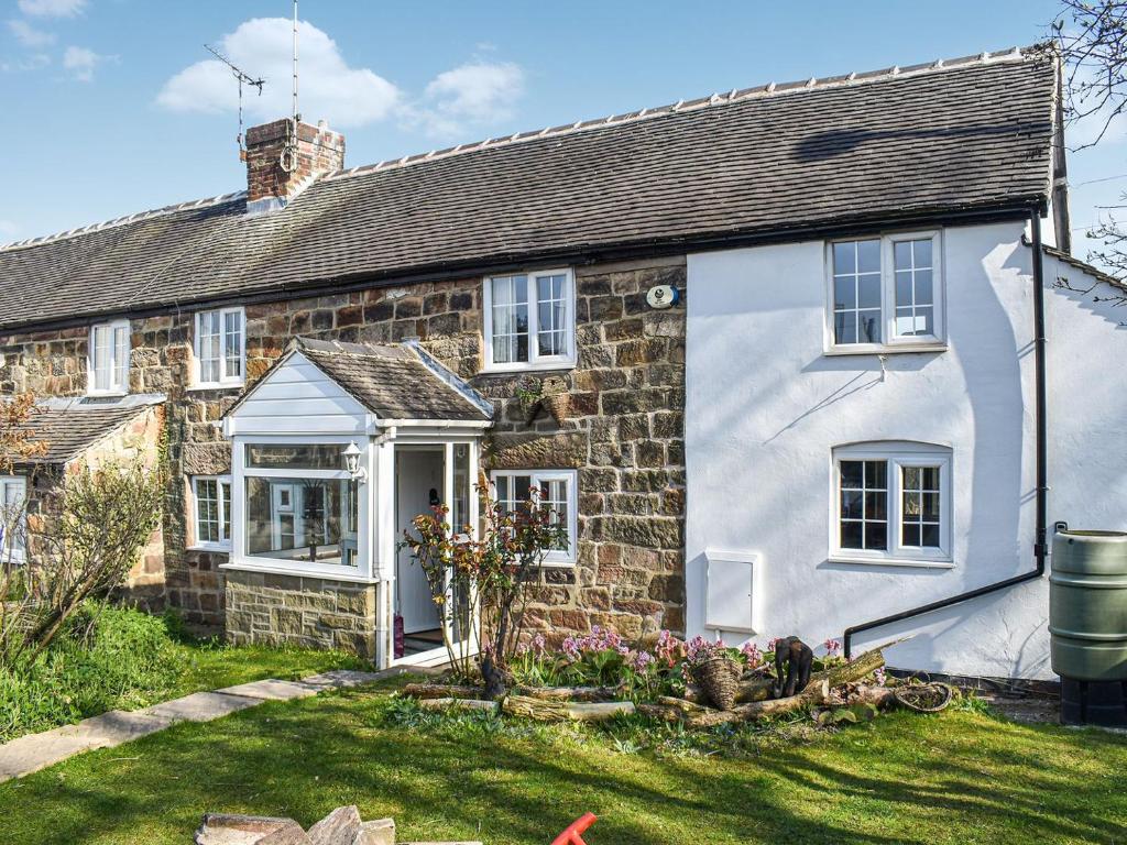 an old stone house with a garden in front of it at Windmill Cottage in Little Eaton