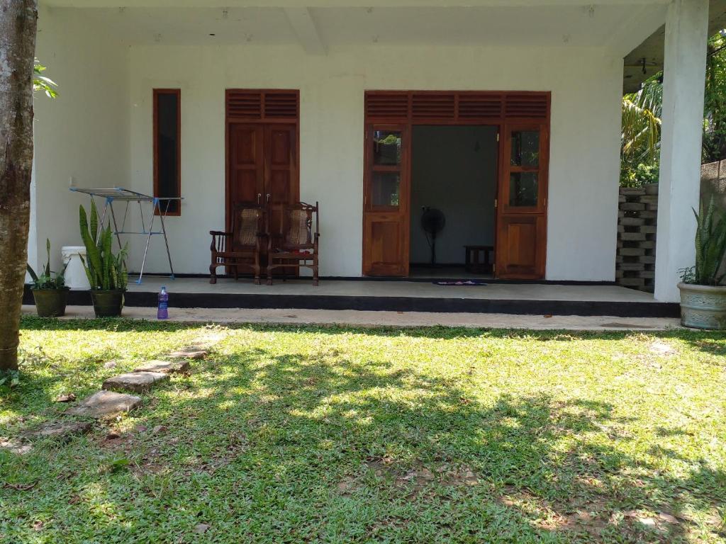 Villa Ameliya في يوناواتونا: بيت أبيض بأبواب خشبية وساحة