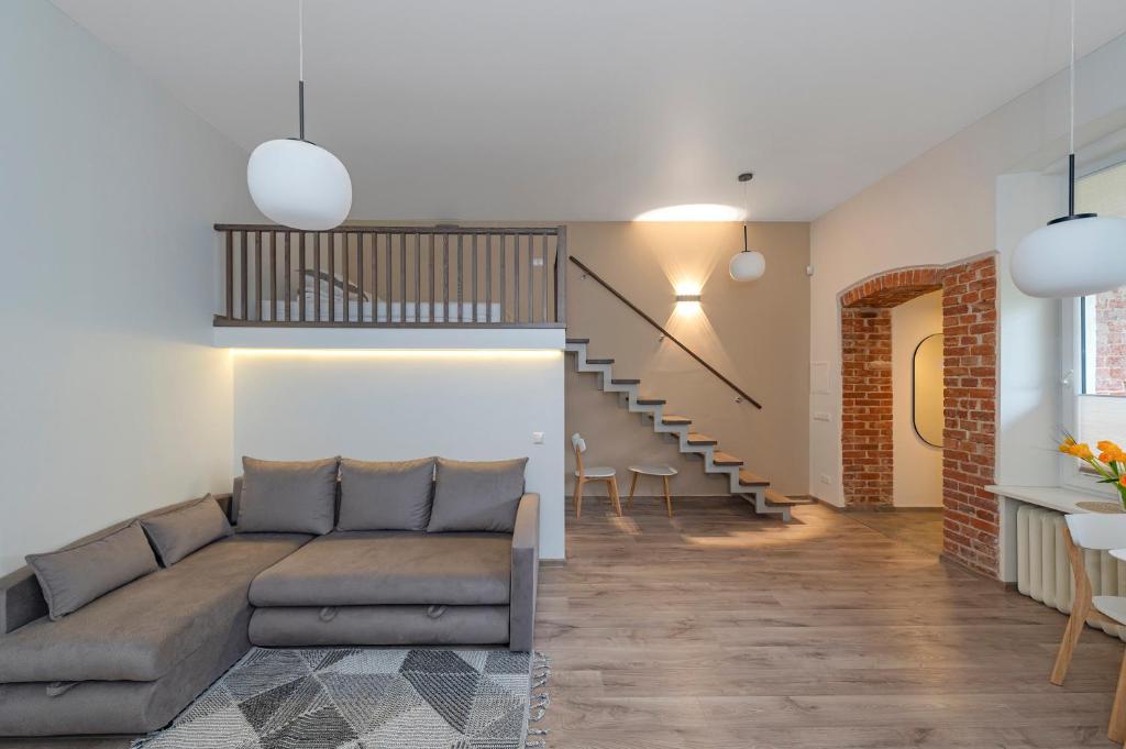 a living room with a couch and a staircase at Freedom Avenue Apartment by Polo apartments in Kaunas