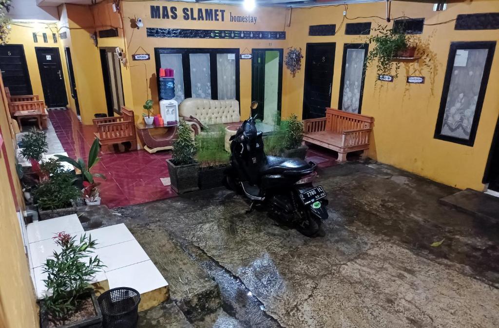 een motorfiets geparkeerd voor een gebouw bij Kosan Syariah Mas Slamet in Tasikmalaya