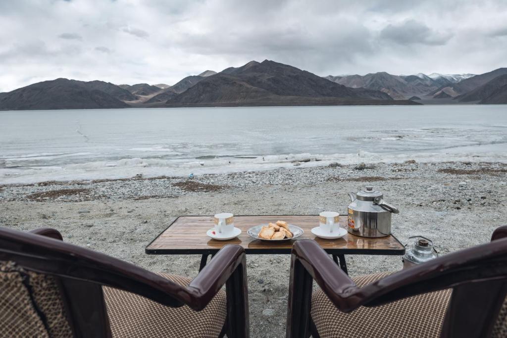 a table with a plate of food and two chairs at Astrostays at Pangong in Spangmik