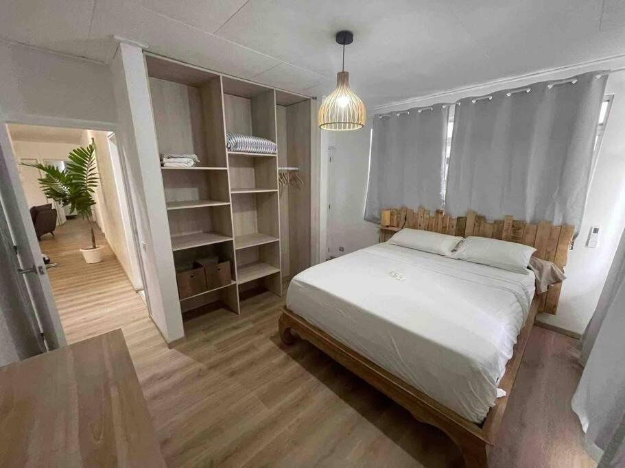 Heitiare lodge في Paea: غرفة نوم مع سرير وزرع الفخار