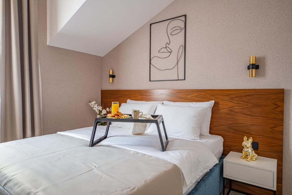 a hotel room with a bed with a table on it at Enyana Luxury Suites in Kotor