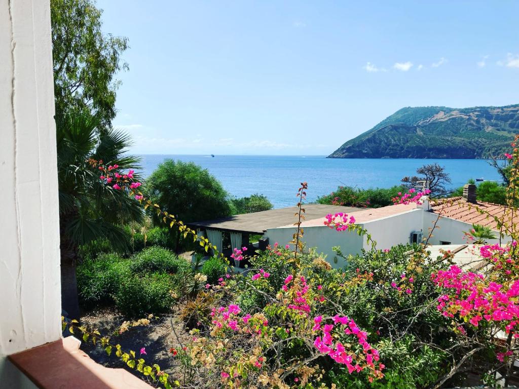 een uitzicht op de oceaan vanuit een huis met bloemen bij Jerà Holiday Collection-Vulcano in Vulcano