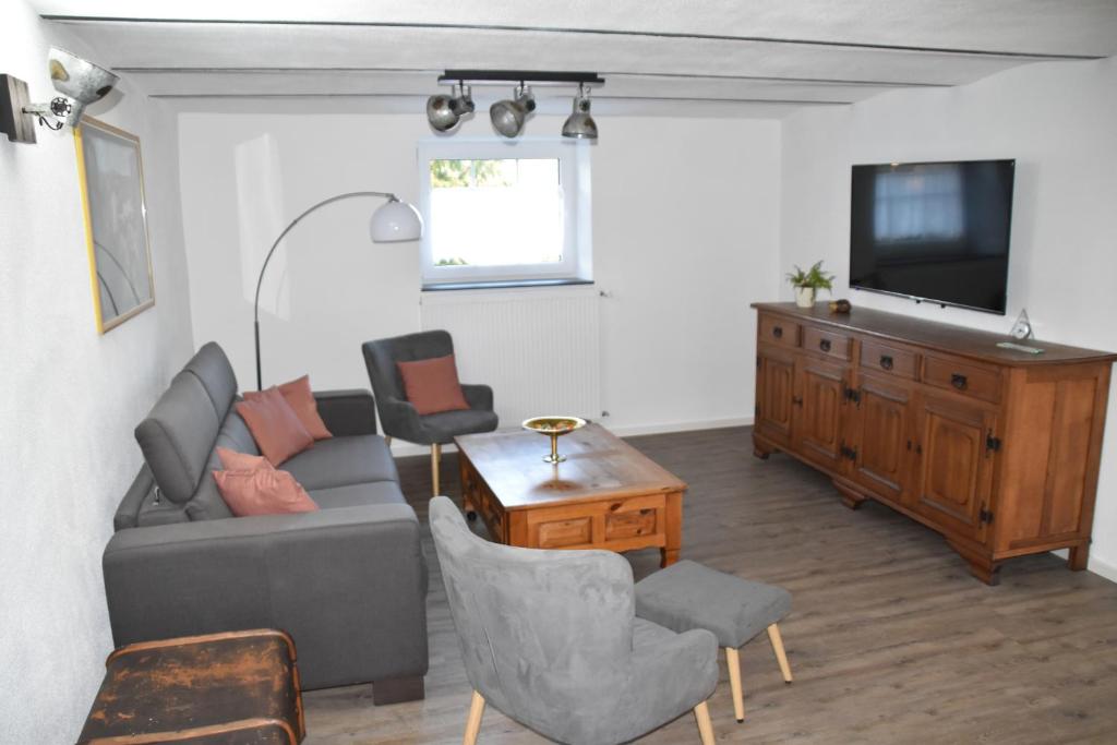 a living room with a couch and a tv at Ferienwohnung-Naurath in Naurath