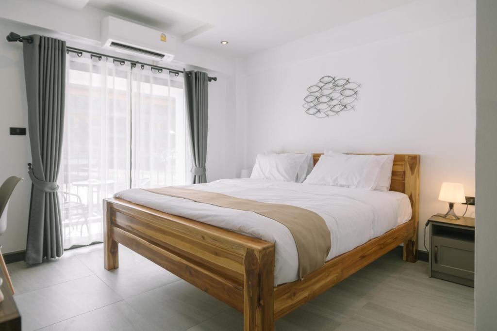 um quarto com uma cama grande e uma janela em ONE LODGE Pattaya em Pattaya Central