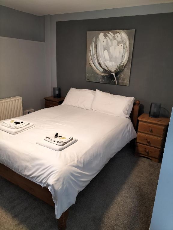 a bedroom with a large white bed with two trays on it at The Castle Inn in Ebbw Vale