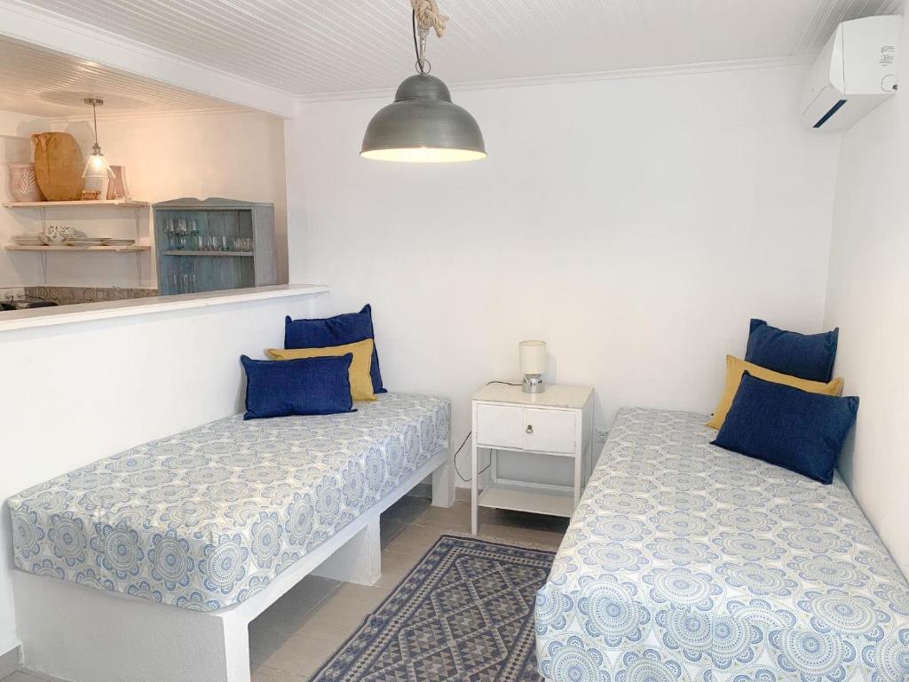 2 Betten in einem Zimmer mit blauen und gelben Kissen in der Unterkunft The Guest House in Skiathos-Stadt