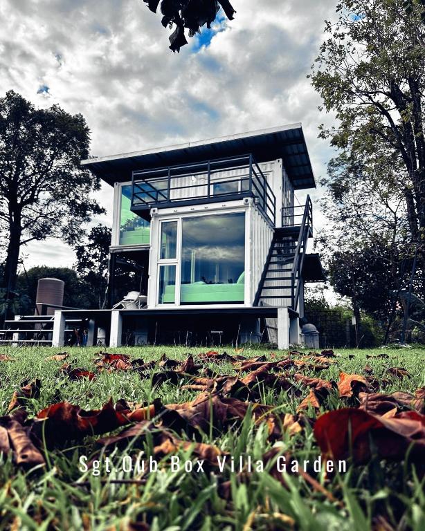 a small house on a grassy field in front at Sgt.Oub Box Villa Garden in Ban Som Phung Haeng (1)